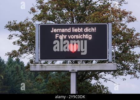 Jemand liebt Dich Fahr vorsichtig. Seit April schmücken 17 digitale Verkehrstafeln in Köln zeitweise humorvolle Sprüche auf Kölsch. Diese Botschaften, die normalerweise für Verkehrsinfos genutzt werden, erscheinen nur, wenn keine Staus oder Gefahren gemeldet werden müssen. Insgesamt werden drei verschiedene kölsche Nachrichten für die Autofahrerinnen und Autofahrer angezeigt. *** Qualcuno ti ama guidare con attenzione. Da aprile, 17 segnali stradali digitali a Colonia sono stati temporaneamente adornati con canti umoristici a Kölsch. Questi messaggi, che vengono normalmente utilizzati solo per le informazioni sul traffico Foto Stock