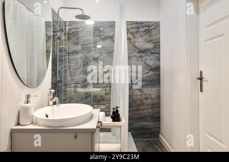 Un bagno moderno con un'elegante doccia in marmo e un elegante design estetico Foto Stock