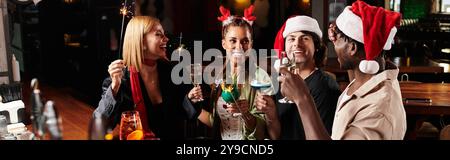 I colleghi si divertono con drink, risate e allegria festosa in un vivace raduno aziendale. Foto Stock