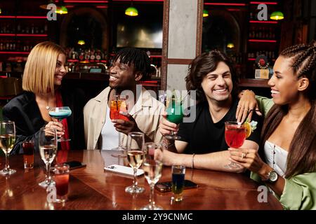 I colleghi condividono momenti di gioia sorseggiando cocktail colorati in un'atmosfera vivace. Foto Stock