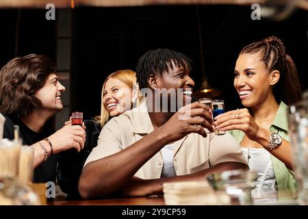 I giovani professionisti si divertono a vicenda, condividendo Risate e bevande durante una festa vivace. Foto Stock