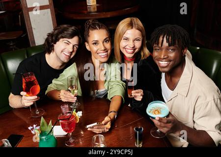 I giovani professionisti si divertono con drink e risate mentre fanno networking in un vivace raduno aziendale. Foto Stock