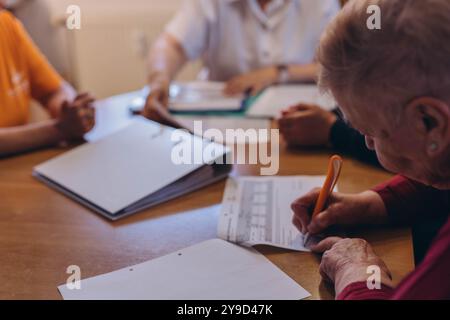 Una vecchia donna vicino tiene la mano firma firma contratto firma firma. Una donna firma un testamento. Foto di alta qualità Foto Stock