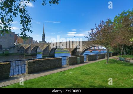 La fotografia mostra il fiume Ayr che scorre attraverso la città di Ayr. Bella giornata di sole. Guardando a ovest verso Auld Brig di Ayr. Presa guardando a ovest, in fondo a Riv Foto Stock