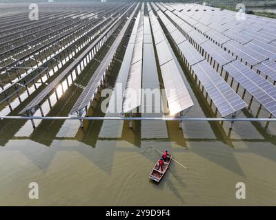 SUQIAN, CINA - 10 OTTOBRE 2024 - Un lavoratore controlla le apparecchiature fotovoltaiche in una base ibrida pescheria-solare a Suqian, nella provincia di Jiangsu nella Cina orientale, ottobre Foto Stock