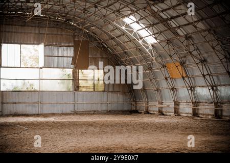 Rustica arena al coperto con luce naturale in streaming attraverso finestre alte. Foto Stock