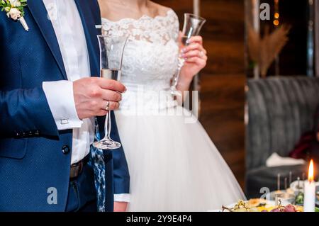 Elegante celebrazione nuziale con brindisi di coppia in un abbigliamento formale. Foto Stock