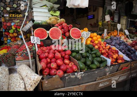 Bancarelle, mercato Machane Yehuda, a destra, prodotti: Mele, angurie, melograni, arance, avocado, nettarine e prugne, sinistra: caramelle, dolci e farinata d'avena. Foto Stock