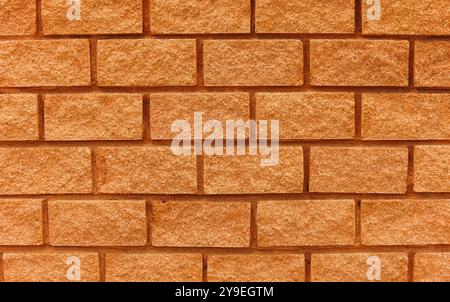 Mattoni a strati da una parete arancione e rossa da utilizzare come trama o motivo. Perfetto per design voluminosi, robusti, urbani o alternativi. Foto Stock