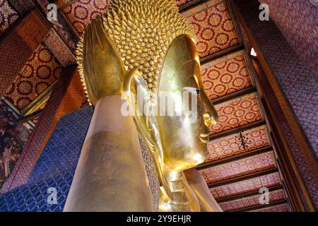 Wat Pho, scritto anche Wat po, è un complesso di templi buddisti nel distretto di Phra Nakhon, Bangkok, Thailandia. Conosciuto anche come il Tempio del Buddha sdraiato, il suo nome ufficiale è Wat Phra Chetuphon Wimon Mangkhalaram Rajwaramahawihan. Il Buddha reclinato, la figura è alta 15 m e lunga 46 m, ed è una delle più grandi statue di Buddha in Thailandia. La figura ha un nucleo di mattoni, modellato e modellato con intonaco, poi dorato. Foto Stock