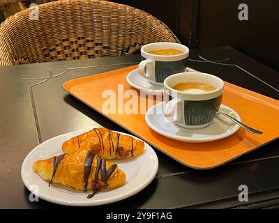 Due tazze di caffè e due torte di pasta sfoglia. Foto Stock