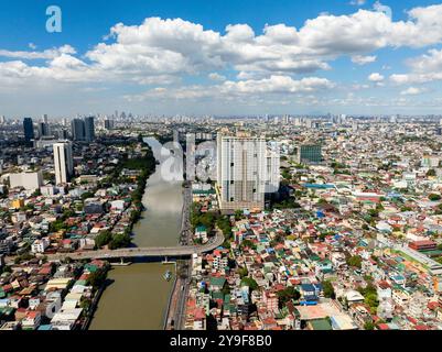 Paesaggio urbano: Veduta da droni di edifici moderni, hotel e case sul lungofiume. Manila, Filippine. Foto Stock