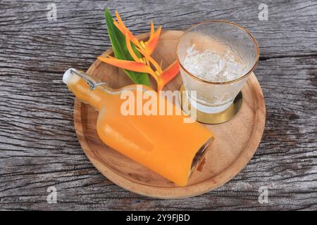 Succo d'arancia appena spremuto con polpa d'arancia disporre su un vassoio di legno servito con piccoli fiocchi di ghiaccio Foto Stock