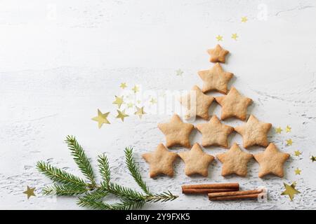 Albero di Natale fatto con biscotti fatti in casa a forma di stelle su sfondo azzurro, vista dall'alto Foto Stock