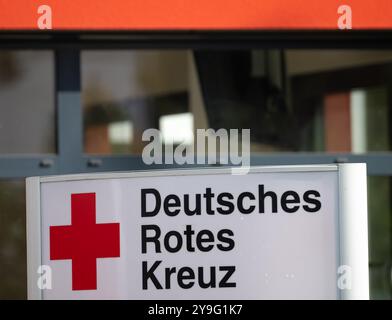 Berlino, Germania. 10 ottobre 2024. Un cartello con la scritta "Deutsches Rotes Kreuz" (Croce Rossa tedesca, DRK) si trova di fronte all'ingresso di una casa. Credito: Soeren Stache/dpa/Alamy Live News Foto Stock