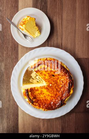 Famosa cheesecake basca di San Sebastián, Spagna, su un tavolo di legno, servita su piatti bianchi. Foto Stock