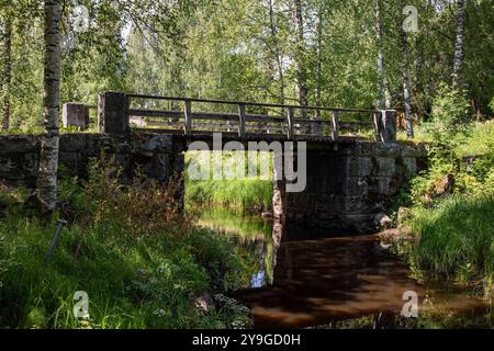 Vecchio ponte in pietra su un piccolo fiume o un torrente vicino a Serlachius Manor a Mänttä-Vilppula, Finlandia Foto Stock