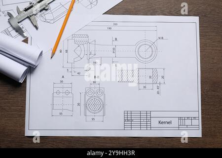 Disegni tecnici diversi, calibro a corsoio e matita su tavolo in legno, vista dall'alto Foto Stock