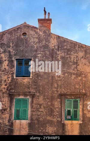 Finestre con persiane in un edificio in pietra nella città vecchia di Dubrovnik, Croazia Foto Stock