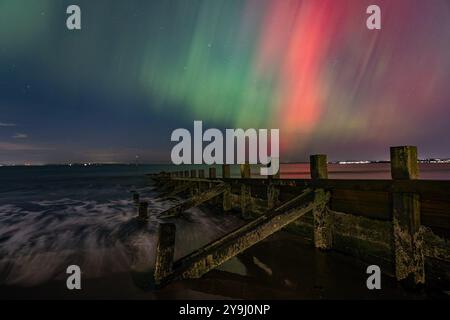 Edimburgo, Regno Unito. 10 ottobre 2024 nella foto: L'aurora boreale visibile su un groyne sulla spiaggia di Portobello vicino Edimburgo. L'aurora boreale (o aurora boreale) era visibile su gran parte del Regno Unito. Crediti: Rich Dyson/Alamy Live News Foto Stock