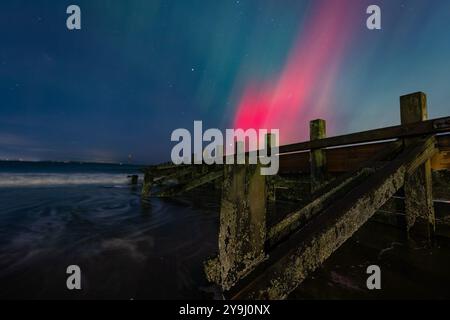 Edimburgo, Regno Unito. 10 ottobre 2024 nella foto: L'aurora boreale visibile su un groyne sulla spiaggia di Portobello vicino Edimburgo. L'aurora boreale (o aurora boreale) era visibile su gran parte del Regno Unito. Crediti: Rich Dyson/Alamy Live News Foto Stock