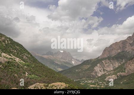 Cime ricoperte di nuvole e verdi pendii boscosi del Bois du Clot, Alpi francesi Foto Stock