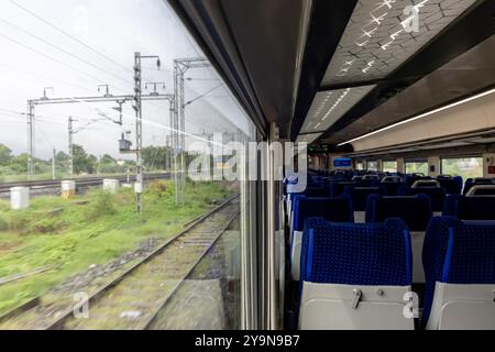 Pullman passeggeri con posto a sedere libero e vista finestra durante il giorno, viene scattata l'immagine del treno ad alta velocità Vande bharat o del treno ferroviario indiano ad Abu ro Foto Stock