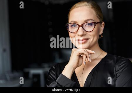 Una giovane e bella donna di grandi dimensioni si impegna nel suo lavoro mentre mostra eleganza alla sua scrivania. Foto Stock