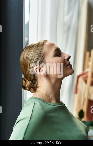 Una giovane donna di grandi dimensioni gode di un momento tranquillo, riposando pacificamente vicino alla finestra. Foto Stock