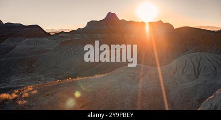 Montagne di sabbia del deserto con il sole che tramonta dietro le vette Foto Stock