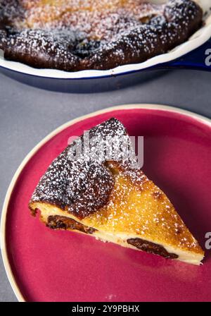 Una fetta di torta tra Breton Custard su Un piatto rosso Foto Stock