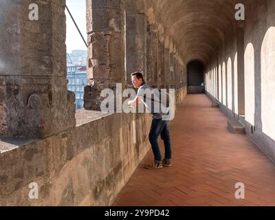 Viaggiatore che si appoggia su un recinto d'epoca e guarda lontano Foto Stock