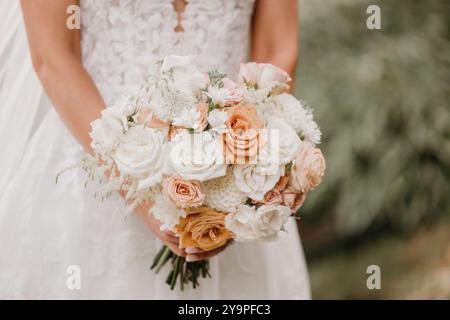 Sposa in un abito da sposa in pizzo con bouquet Foto Stock