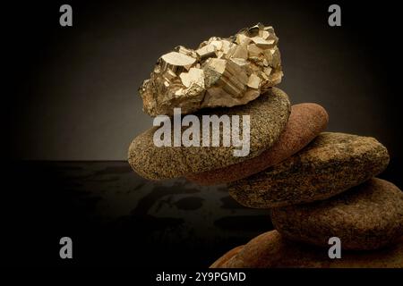 Cristallo di pirite in equilibrio su un cairn di rocce fluviali Foto Stock