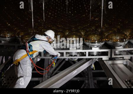 (241011) -- JIANGMEN, 11 ottobre 2024 (Xinhua) -- Qin Zhonghua lavora nel cantiere dell'Osservatorio neutrino sotterraneo di Jiangmen (JUNO) a Jiangmen, nella provincia del Guangdong della Cina meridionale, 9 ottobre 2024. La Cina ha costruito il rivelatore sferico trasparente più grande del mondo a 700 metri sottoterra per catturare neutrini sfuggenti, spesso soprannominati "particelle fantasma", per svelare i segreti di infinitesimamente piccoli e infinitamente vasti dell'universo. La sfera acrilica alta 12 piani con un diametro di 35,4 metri, sepolta in profondità in uno strato di granito di una collina a Kaiping, Jiangmen City in sou Foto Stock