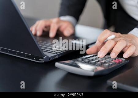 Primo piano uomo d'affari con la calcolatrice per calcolare la finanza domestica e la nota di scrittura, la contabilità in tabella, la gestione del budget. Finanza, budgetin Foto Stock