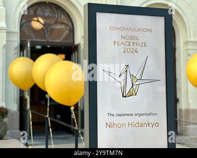 Oslo, Norvegia. 11 ottobre 2024. Di fronte al Centro Nobel per la pace di Oslo, il premio Nobel per la pace di quest'anno, l'organizzazione giapponese Nihon Hidankyo, si congratula. L'organizzazione giapponese Nihon Hidankyo, fondata dai sopravvissuti ai bombardamenti atomici di Hiroshima e Nagasaki, ha ricevuto il Premio Nobel per la pace di quest'anno, come annunciato dal Comitato Nobel norvegese di Oslo. Crediti: Steffen Trumpf/dpa/Alamy Live News Foto Stock