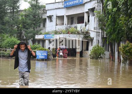 I popoli stanno arrivando in un ospedale governativo colpito dalle inondazioni per ricevere cure nel distretto di beni, in Bangladesh, il 25 agosto 2024. Foto Stock