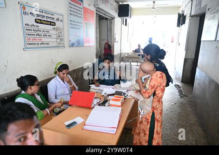 Persone che prendono trattamento in un ospedale governativo durante l'alluvione nel distretto di Feni, Bangladesh, il 25 agosto 2024 Foto Stock