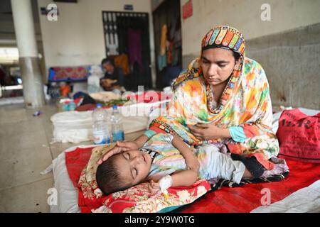 Persone che prendono trattamento in un ospedale governativo durante l'alluvione nel distretto di Feni, Bangladesh, il 25 agosto 2024 Foto Stock