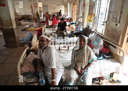 Persone che prendono trattamento in un ospedale governativo durante l'alluvione nel distretto di Feni, Bangladesh, il 25 agosto 2024 Foto Stock