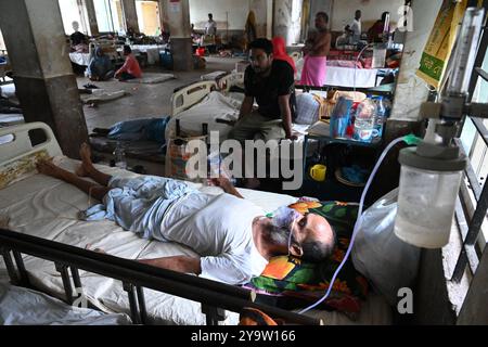 Persone che prendono trattamento in un ospedale governativo durante l'alluvione nel distretto di Feni, Bangladesh, il 25 agosto 2024 Foto Stock