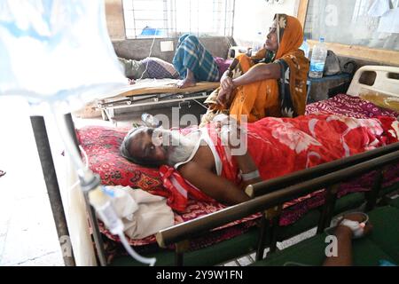 Persone che prendono trattamento in un ospedale governativo durante l'alluvione nel distretto di Feni, Bangladesh, il 25 agosto 2024 Foto Stock