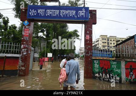 I popoli stanno arrivando in un ospedale governativo colpito dalle inondazioni per ricevere cure nel distretto di beni, in Bangladesh, il 25 agosto 2024. Foto Stock