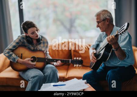 Padre e figlia suonano le chitarre acustiche insieme a casa Foto Stock