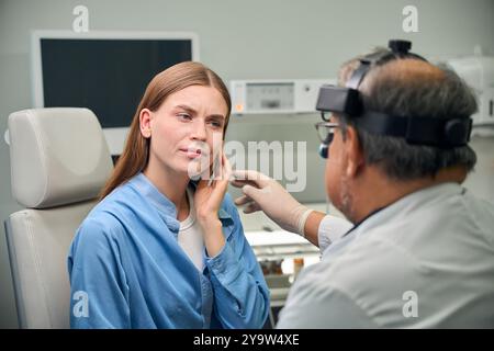 Medico adulto e paziente che discutono di condizioni dell'orecchio Foto Stock