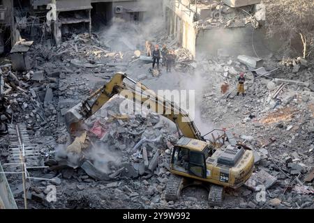 Beirut, Libano. 11 ottobre 2024. Le persone ripuliscono le macerie degli edifici danneggiati dopo gli attacchi aerei israeliani a Beirut, Libano, 11 ottobre 2024. Israele ha continuato a perseguire le offensive in Libano e nella Striscia di Gaza giovedì, portando avanti i suoi obiettivi militari sui due fronti. Giovedì sera, Israele ha lanciato pesanti attacchi aerei sul centro di Beirut, contro Wafiq Safa, capo dell'unità di collegamento e coordinamento di Hezbollah. Lo sciopero ha provocato almeno 22 morti e 117 feriti, secondo il Ministero della salute libanese. Crediti: Bilal Jawich/Xinhua/Alamy Live News Foto Stock