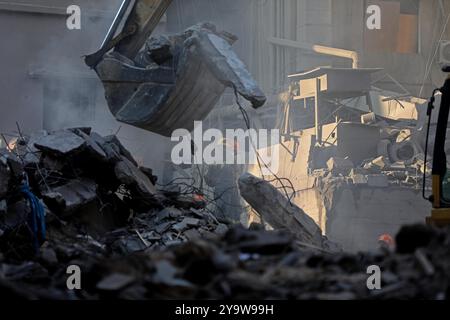 Beirut, Libano. 11 ottobre 2024. Le persone ripuliscono le macerie degli edifici danneggiati dopo gli attacchi aerei israeliani a Beirut, Libano, 11 ottobre 2024. Israele ha continuato a perseguire le offensive in Libano e nella Striscia di Gaza giovedì, portando avanti i suoi obiettivi militari sui due fronti. Giovedì sera, Israele ha lanciato pesanti attacchi aerei sul centro di Beirut, contro Wafiq Safa, capo dell'unità di collegamento e coordinamento di Hezbollah. Lo sciopero ha provocato almeno 22 morti e 117 feriti, secondo il Ministero della salute libanese. Crediti: Bilal Jawich/Xinhua/Alamy Live News Foto Stock