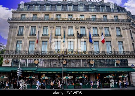 Traffico e fascino: Vita di strada in due attrazioni parigine, il Grand Hotel e il Café de la Paix a Parigi Foto Stock