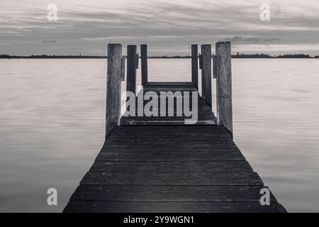 Foto di un molo di legno sul lago. Il cielo è splendidamente colorato. Vicino a Giethoorn, Weerribben nei Paesi Bassi. Foto Stock